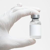 Premium PSD _ Injection bottle with label mockup in nurse’s hand Premium PSD _ Injection bottle with label mockup in nurse's hand